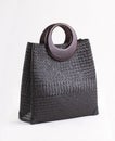 Black wicker handbag with wooden handles isolated