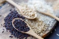 Black wild rice, brown wild rice and white jasmine rice in wooden spoon flat lay. Creative layout. Food concept. Focus on black Royalty Free Stock Photo