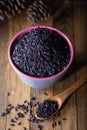 Black wild rice in ceramic bowl on wooden background. Thai black jasmine rice Rice berry Royalty Free Stock Photo