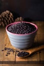 Black wild rice in ceramic bowl on wooden background. Thai black jasmine rice Rice berry Royalty Free Stock Photo