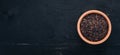 Black wild rice in a plate on a wooden background.