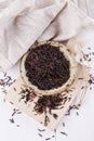 Black wild rice in a rustic ceramic plate on a white wooden background Royalty Free Stock Photo