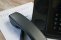 Black wire phone on top of an important document on the table Royalty Free Stock Photo