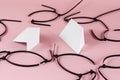 Black wire ties and white abstract geometric shapes on a pink background. Old cut plastic ties randomly on colored background