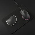 Black wired computer mouse placed on a rectangular black mouse p Royalty Free Stock Photo