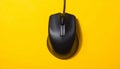 Black Wired Computer Mouse with Scroll Wheel on a Bright Yellow Textured Background wired mouse Royalty Free Stock Photo