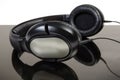 Black wired earspeakers with full size headphones Royalty Free Stock Photo