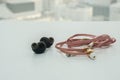 Black wireless bluetooth earbuds vs pink wire earphone for music listening Royalty Free Stock Photo