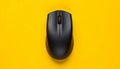 Black Wireless Computer Mouse Centered on a Vibrant Yellow Background wireless mouse black mouse Royalty Free Stock Photo