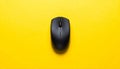 Black Wireless Computer Mouse Centered on a Vibrant Yellow Textured Background wireless mouse Royalty Free Stock Photo