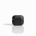 black wireless earbuds case on white reflective surface Royalty Free Stock Photo