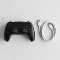 Black wireless game controller for a PlayStation console sits on a smooth Royalty Free Stock Photo
