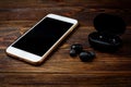 Black wireless headphones and mobile phone on dark wooden background Royalty Free Stock Photo