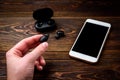 Black wireless headphones and mobile phone on dark wooden background Royalty Free Stock Photo