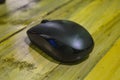 a black wireless mouse on a wooden table Royalty Free Stock Photo