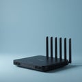 A black wireless router with six external antennas is positioned against a light blue Royalty Free Stock Photo