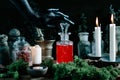 Black witch hand opening magic potion, herbs ingredients candles and magical equipment Royalty Free Stock Photo