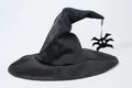 Black witch hat on a white background. Concept of magic and sorcery, stylish hat. Spider