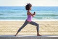 Black woman, afro hairstyle, doing yoga in warrior asana in the