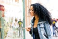 Black woman, afro hairstyle, looking at the shop window Royalty Free Stock Photo