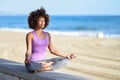 Black woman, afro hairstyle, in lotus pose with eyes closed in t