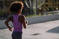 Black woman, afro hairstyle, running outdoors at Sunset