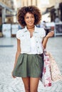 Black woman, afro hairstyle, with shopping bags in the street. Royalty Free Stock Photo