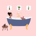 Black woman in bath is relaxing with book and glass of wine. Feminine life, home leisure. Bathroom interior Royalty Free Stock Photo