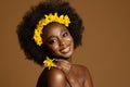 Black Woman Beauty with Yellow Flower. African Model with Curly Coil Hairstyle and Floral Wreath in Hair over Beige Background Royalty Free Stock Photo