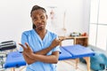 Black woman with braids working at pain recovery clinic pointing to both sides with fingers, different direction disagree