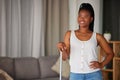 Black woman, broom and cleaning with a smile and mockup in a home living room. Clean house, happy person and relax