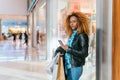 Black woman browsing on her phone in a shopping mall Royalty Free Stock Photo