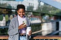 Black woman with coffee using smartphone