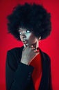 Black woman, confidence and afro, hair and beauty with shine isolated on red background. Hairstyle, haircare and texture Royalty Free Stock Photo