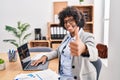 Black woman with curly hair wearing call center agent headset at the office approving doing positive gesture with hand, thumbs up Royalty Free Stock Photo