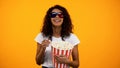 Black woman in 3d glasses eating popcorn and watching comedy movie, leisure
