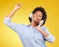 Black woman, dancing with headphones and freedom, music and happiness on yellow studio background. Happy female Royalty Free Stock Photo