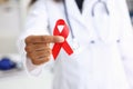 Black woman doctor holding a red ribbon