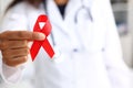 Black woman doctor holding a red ribbon