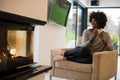 Black woman drinking coffee in front of fireplace