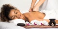 Black woman enjoying massage with candle and flowers nearby Royalty Free Stock Photo