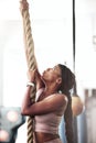 Black woman, fitness and rope climbing at gym for cross workout training for strength, energy and focus of a strong Royalty Free Stock Photo