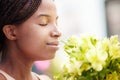 Black woman, flowers and smelling fragrance happy, satisfied and relax face in spring with blossom. Girl, bouquet and Royalty Free Stock Photo