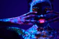 black woman with fluorescent prints on skin, cosmic paint glowing on neon lights