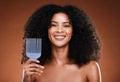 Black woman, hair care and smile in portrait with comb, afro pick or beauty against brown backdrop. Happy African, model Royalty Free Stock Photo