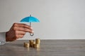 Black woman hand holding umbrella over money to protect her savings Royalty Free Stock Photo