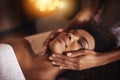 Black woman, hands on face and massage with masseuse, beauty and bodycare at spa for stress relief and wellness