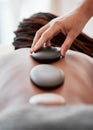 Black woman, hands and rock on back in spa treatment for relaxation, stress relief or massage at resort. Hand of Royalty Free Stock Photo