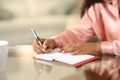 Black woman hands writing in paper agenda at home Royalty Free Stock Photo