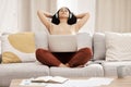 Black woman, headphones and laptop to relax, on couch for wellness and meditation in living room. Young female, girl and Royalty Free Stock Photo